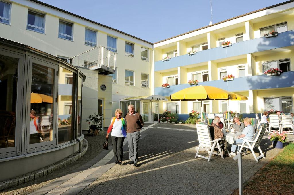 eine Gruppe von Personen, die außerhalb eines Gebäudes stehen in der Unterkunft Aura Hotel in Timmendorfer Strand