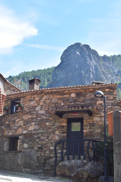 un edificio in pietra con una panchina di fronte di Casa do Neveiro a Góis