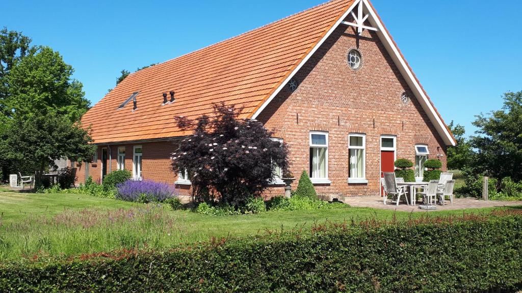 een groot bakstenen huis met een rood dak bij Twentekiek in Delden