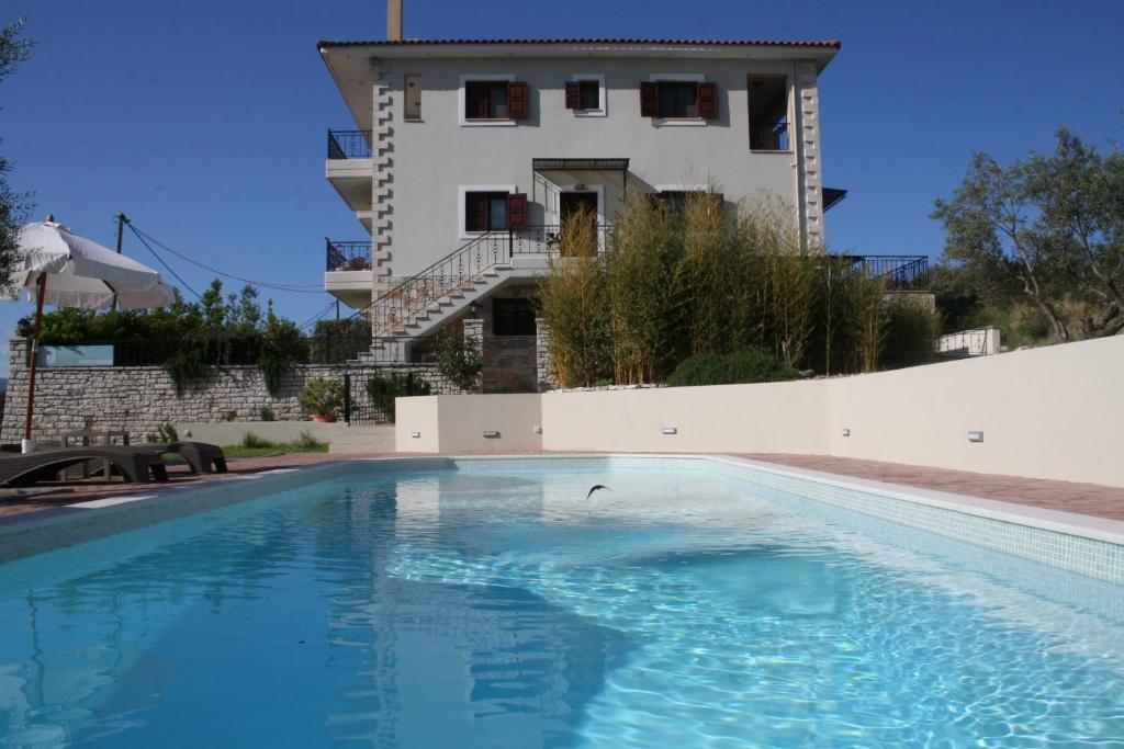 a swimming pool in front of a building at Venetiko Villas in Nafpaktos