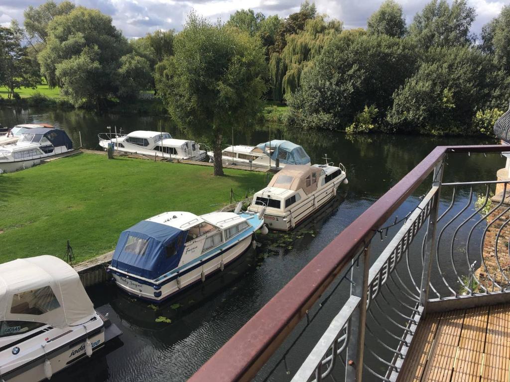 a group of boats docked in a river at Waterfront House In The Heart Of St Neots in Saint Neots