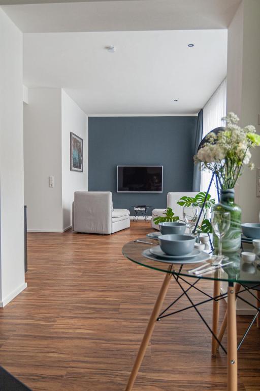 una sala de estar con una mesa y un sofá en Soulfactory Apartments, en Neu-Ulm