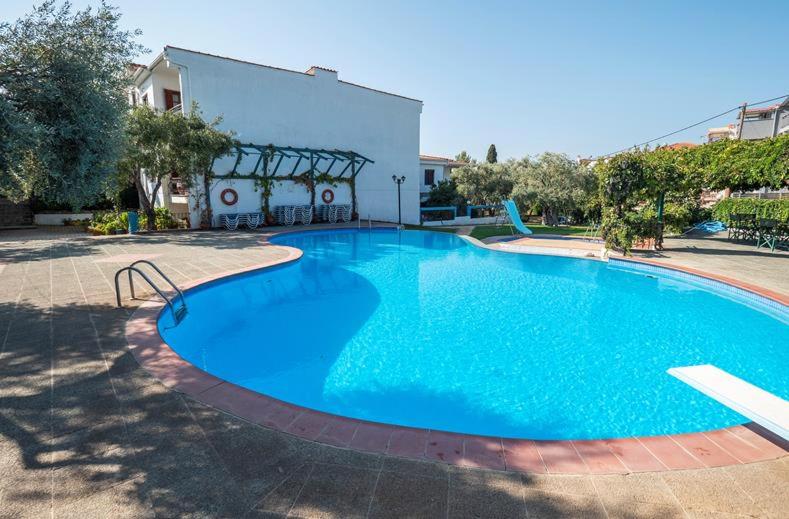 a large blue swimming pool in front of a building at Makedonia in Potos