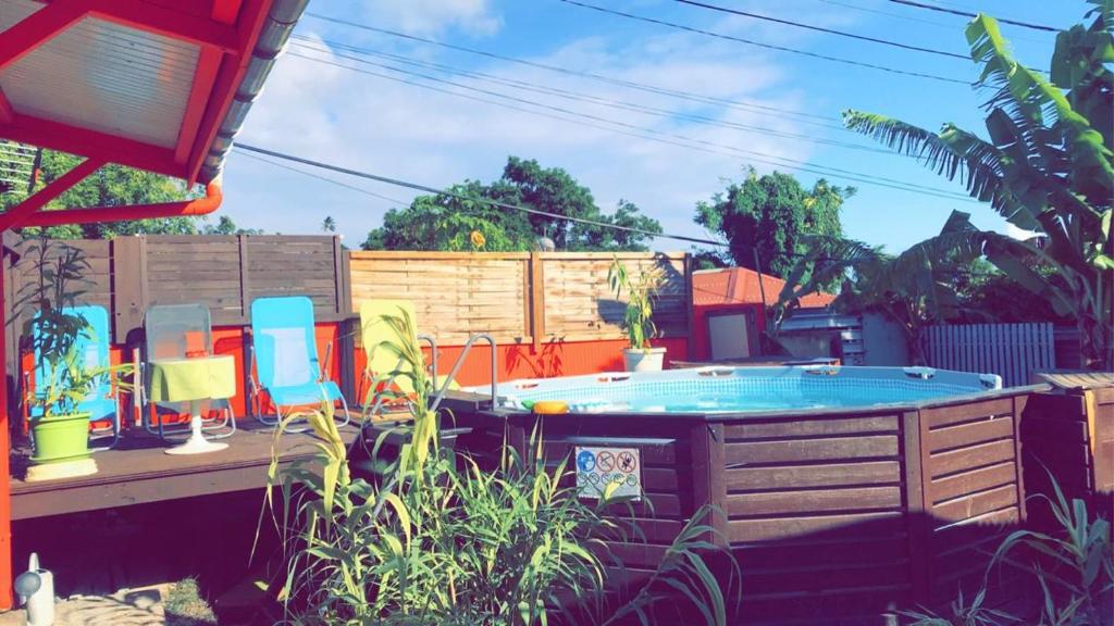 un patio trasero con bañera de hidromasaje y algunas sillas en Bungalow charmant à Trois-Rivières avec piscine privée, en Trois-Rivières