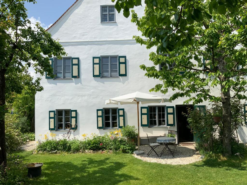 Casa blanca con persianas verdes y patio en Benefizium Denklingen - Anno 1713 en Denklingen