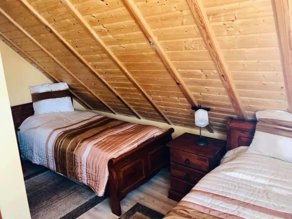 a bedroom with two beds in a log cabin at Domek nad stawem in Sławutowo