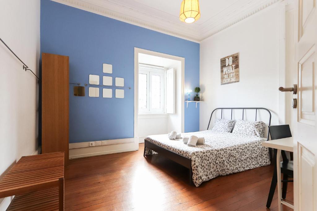 - une chambre avec un lit et un mur bleu dans l'établissement Lisbon Garden Flower, à Lisbonne
