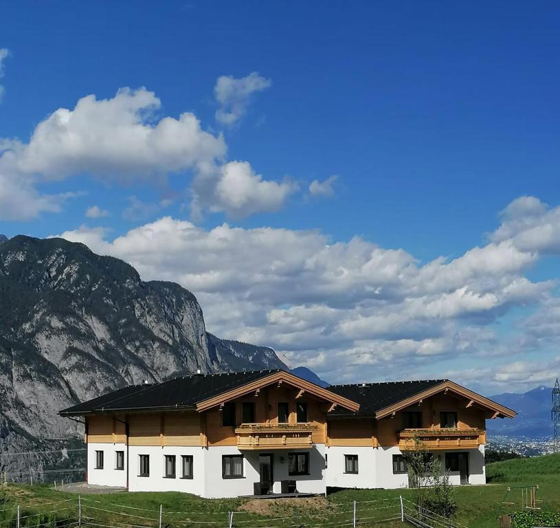 a building with a mountain in the background at Studler Hofchalets in Oberperfuss