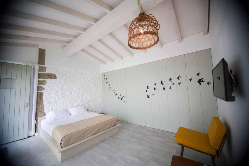 a bedroom with a bed and birds on the wall at Casa Lugar da Aldeia in Barcelos