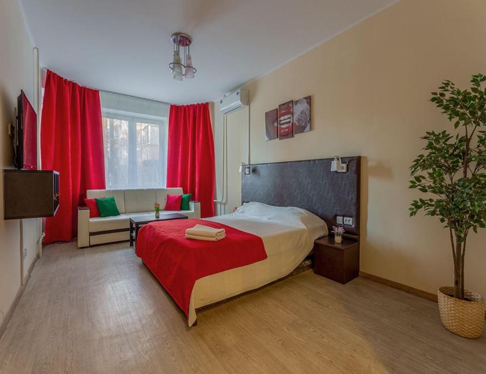 モスクワにあるApartment Hanaka Baikalskaya 18のベッドルーム1室(ベッド1台、ソファ、赤いカーテン付)