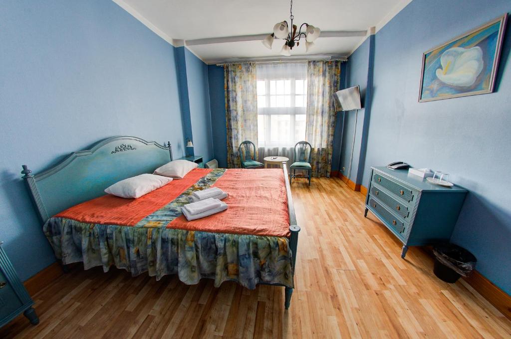 a blue bedroom with a bed and a dresser at Viktorija in Rīga