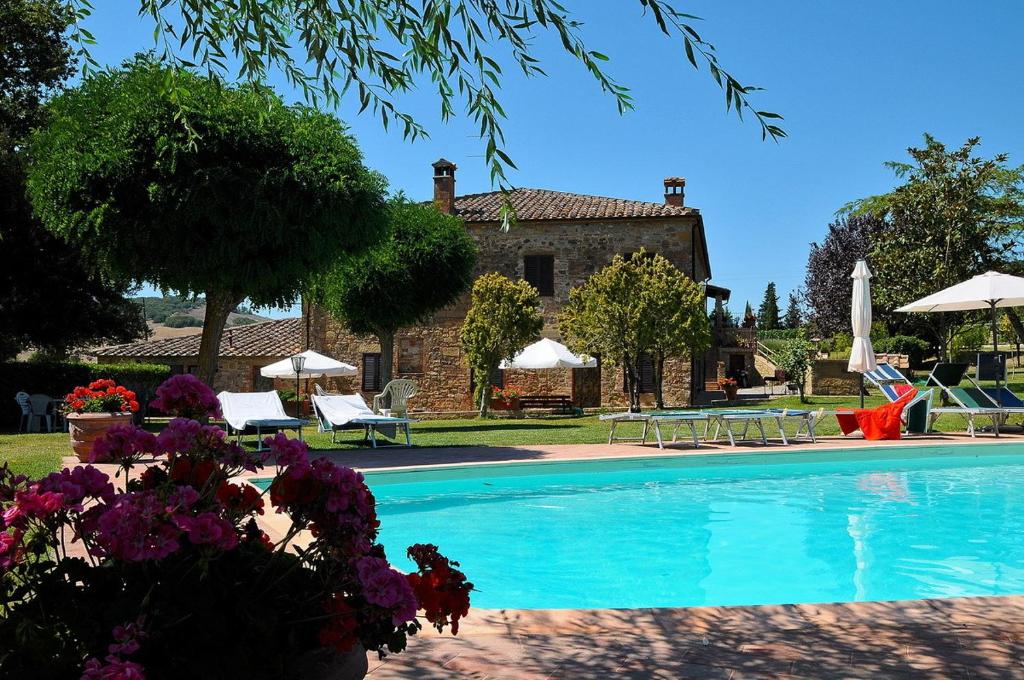 a villa with a swimming pool in front of a house at Agriturismo Casalpiano in Pienza