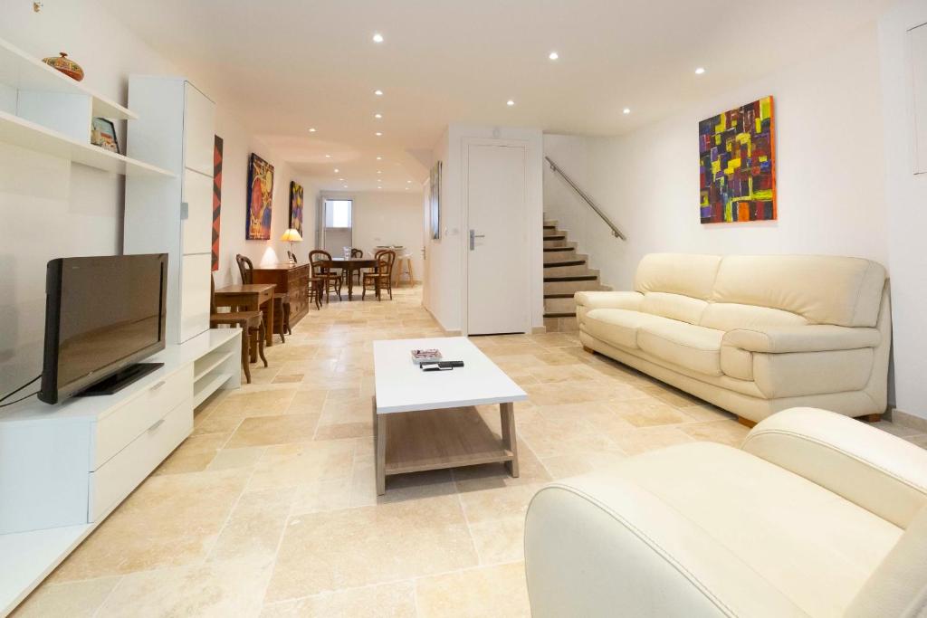 un salon avec un canapé et une télévision dans l'établissement Maison de ville rue Fourmillière, à Antibes