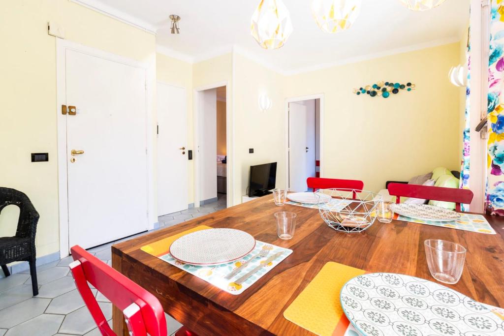 une salle à manger avec une table en bois et des chaises rouges dans l'établissement Place Amiral Barnaud, à Antibes