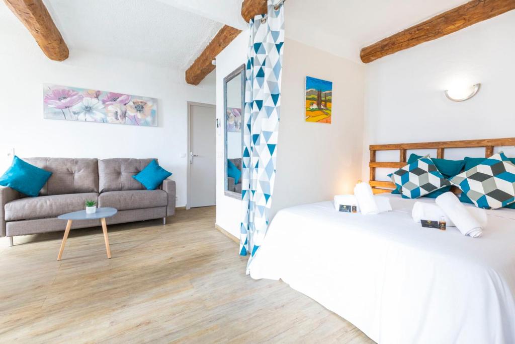ein Wohnzimmer mit 2 Betten und einem Sofa in der Unterkunft Résidence Le Suquet in Cannes