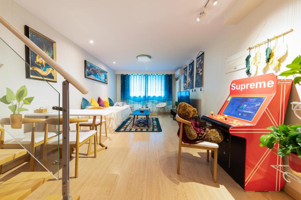 una sala de estar con una máquina de pinball en el centro en Yu Jing Xuan Boutique Apartment en Tianjin