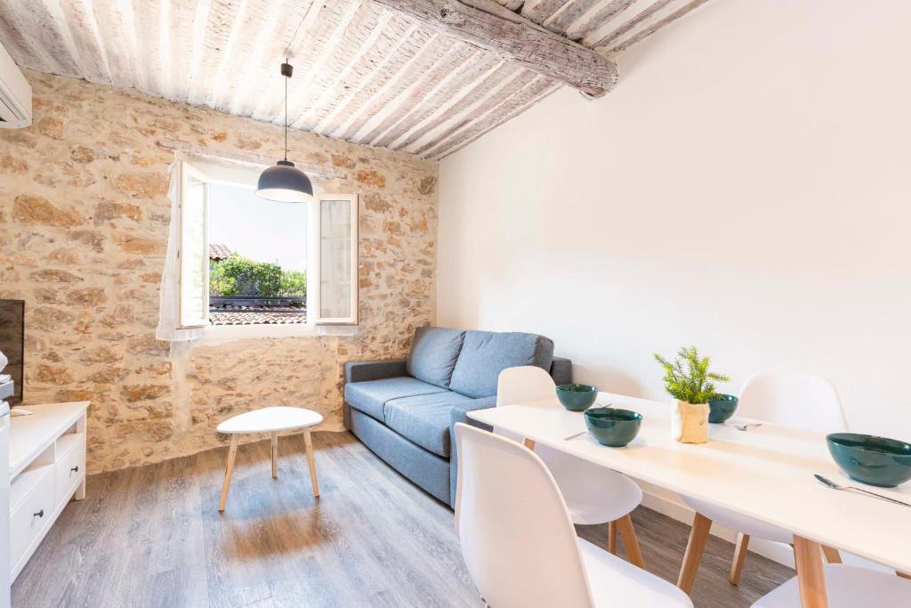 un salon avec un canapé bleu et une table dans l'établissement Chez Dominique - 1 chbre Centre Antibes Migrainier T2 avec AC, à Antibes