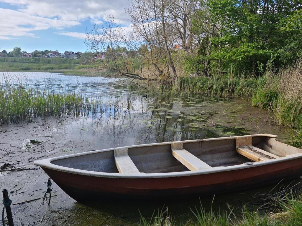 un barco de madera sentado a orillas de un lago en The Old Mill - By the Lake - 2 Bedroom Apartment, en Kruså