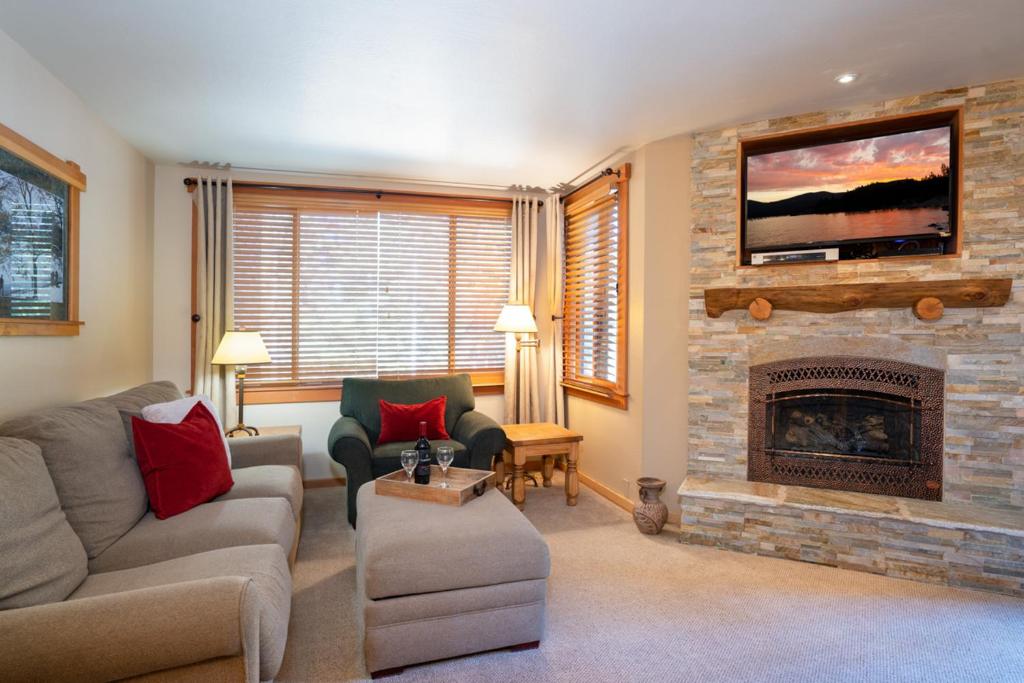 sala de estar con sofá y chimenea en North Star - Ski View Condo en Truckee