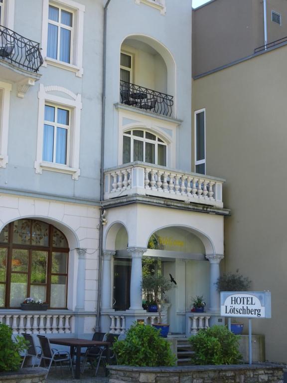a white building with a table in front of it at Hotel Lötschberg in Interlaken