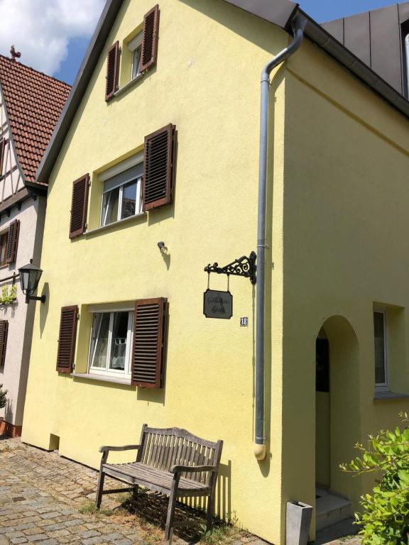 a bench sitting outside of a yellow building at Gästehaus Glock in Marbach am Neckar