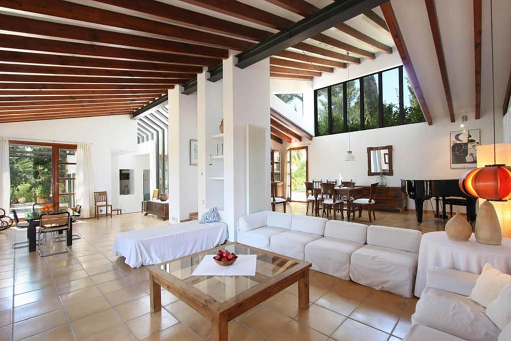 a living room with white furniture and a piano at Villa Can Canaver in Pollença