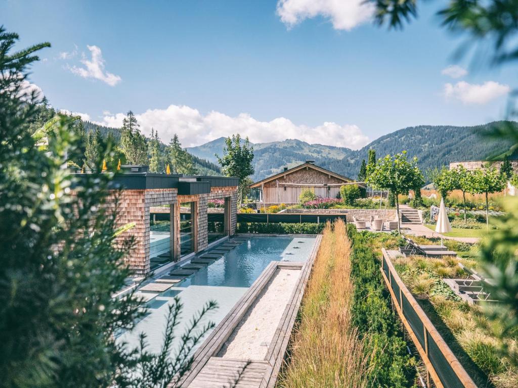 una casa con piscina y montañas en el fondo en Übergossene Alm Resort en Dienten am Hochkönig