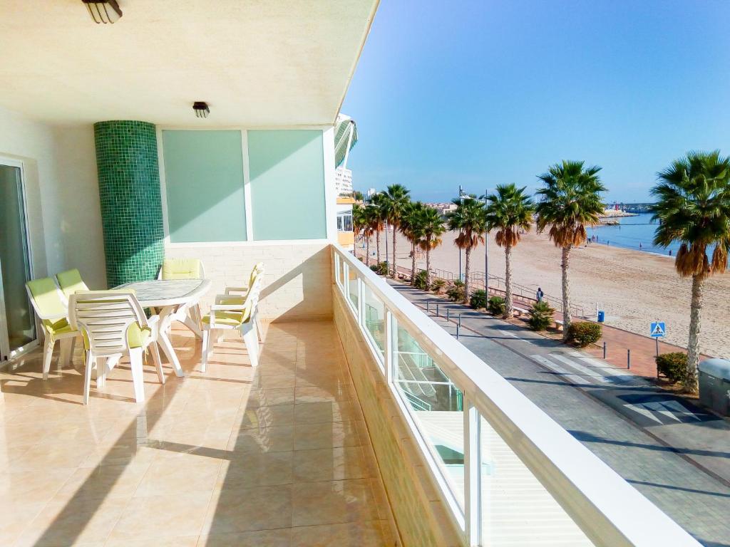 balcón con mesa y sillas y la playa en Gavina Azul, en Villajoyosa