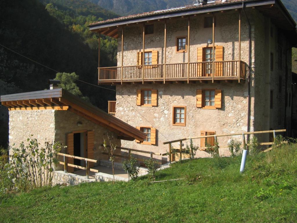 Cette grande maison en pierre possède un balcon sur une colline. dans l'établissement Maso Arlanch 8, à Vallarsa