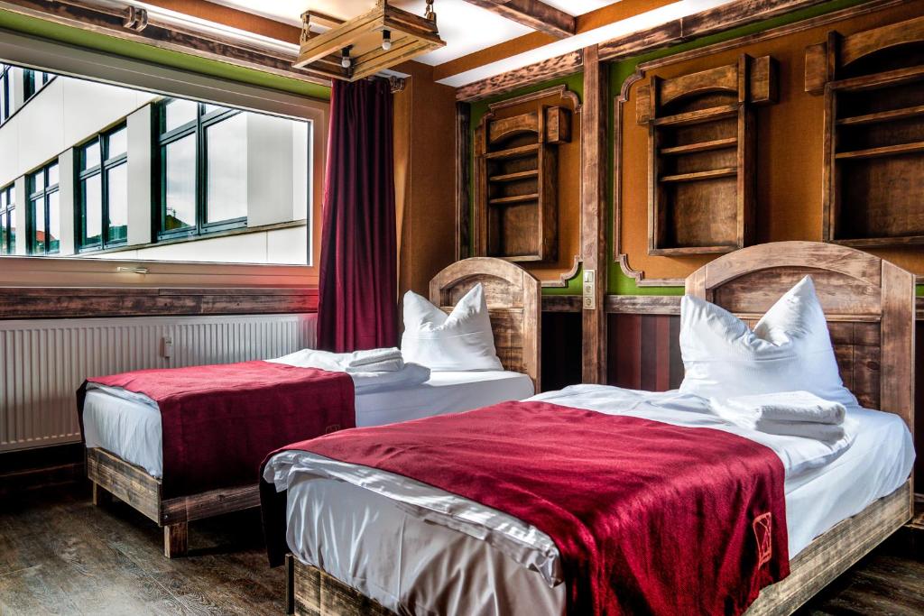 1 dormitorio con 2 camas y ventana en Aparthotel MyCologne en Colonia