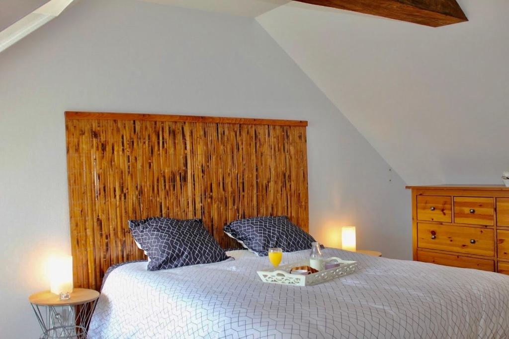 a bedroom with a large bed with a wooden headboard at Royal Confort in Bayeux