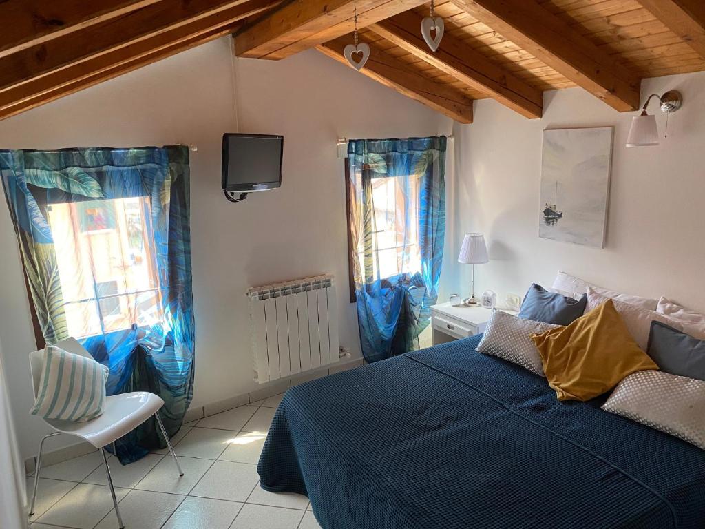キオッジャにあるCasa Napoleoniのベッドルーム1室(青いベッド1台、窓2つ付)