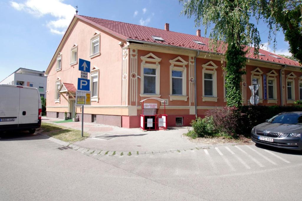 dom z samochodem zaparkowanym przed nim w obiekcie Fehér Hajó Panzió és Vendéglő w Győr