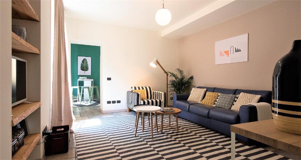 un soggiorno con divano blu e tavolo di Charming & Modern flat by Holiday Solutions a Como
