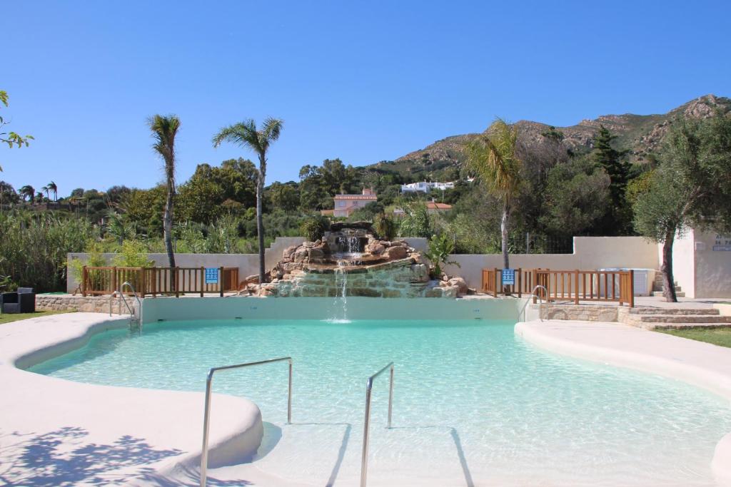 una piscina con cascada en un complejo en Hotel La Torre, en Tarifa