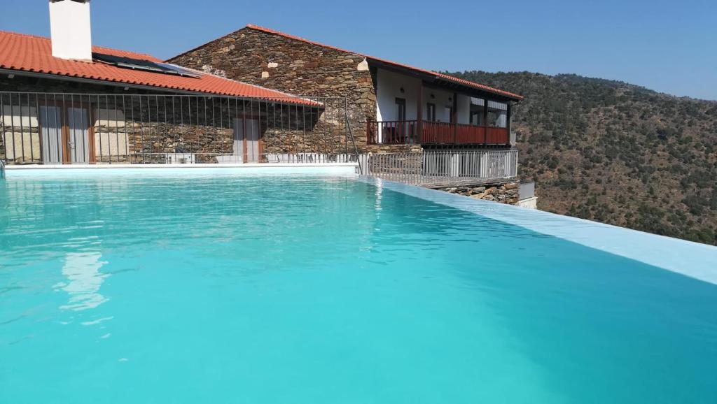 a swimming pool in front of a house at Terraços de Baco in Ribalonga