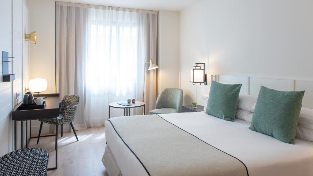 a hotel room with a large bed and two lamps at Molina Lario in Málaga