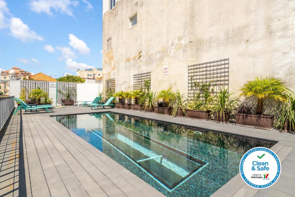 einem Pool vor einem Gebäude mit Pflanzen in der Unterkunft Chalet Estoril Luxury perfect for Families & Friends in Estoril