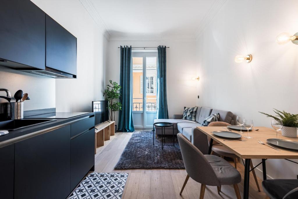 une cuisine et un salon avec une table et un canapé dans l'établissement 12 CONGRES APT3 - Appartement Belles Prestations - Carre d'Or - Clim, à Nice