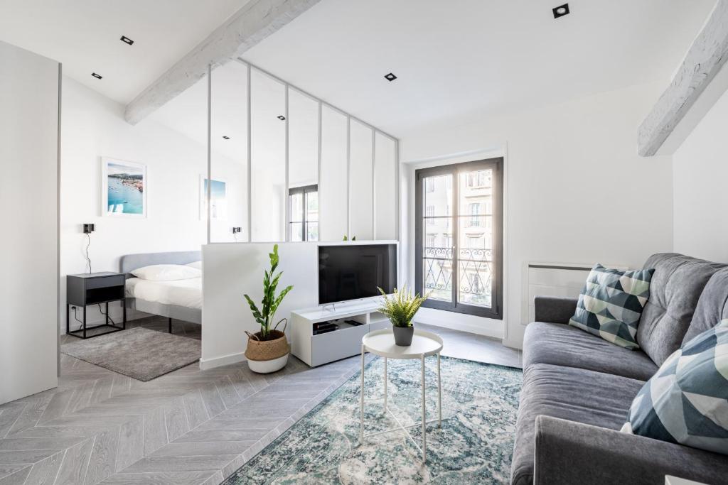 Il comprend un salon blanc doté d'un canapé et d'une télévision. dans l'établissement SMARTBNB - Moderne 2 pieces Port de Nice, à Nice