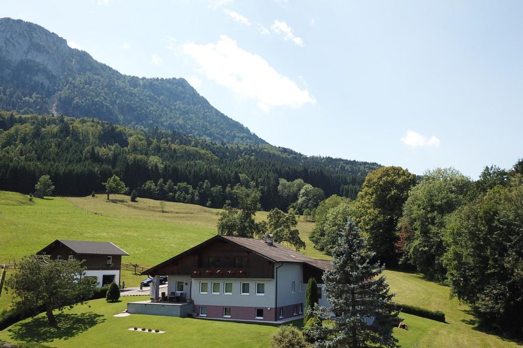 uma casa num campo com uma montanha ao fundo em Am Mondseeblick em Mondsee