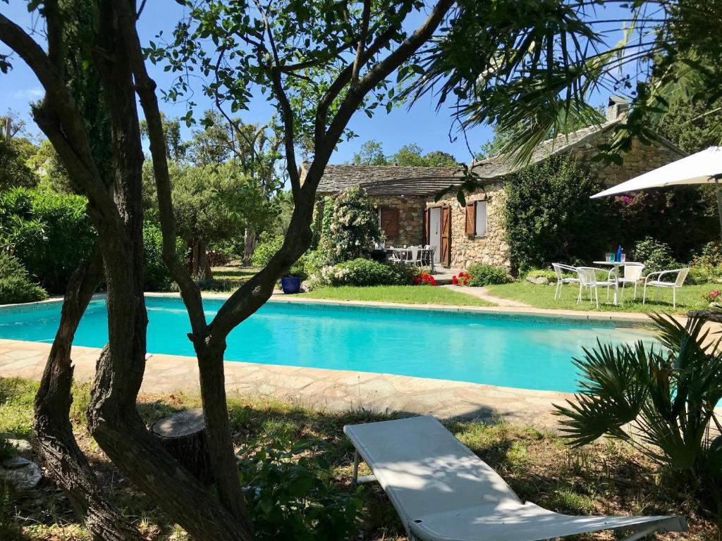Barbaggio的住宿－Les jardins de Foata，享有房屋和游泳池的景致。