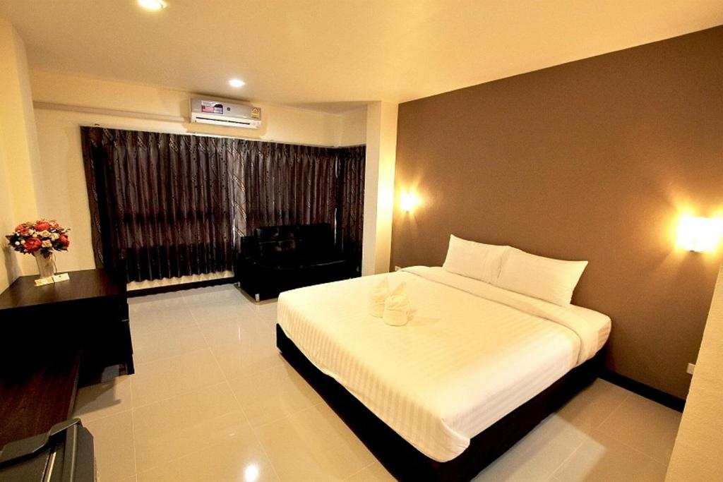 a hotel room with a bed and a window at Panwalee Hotel in Khon Kaen