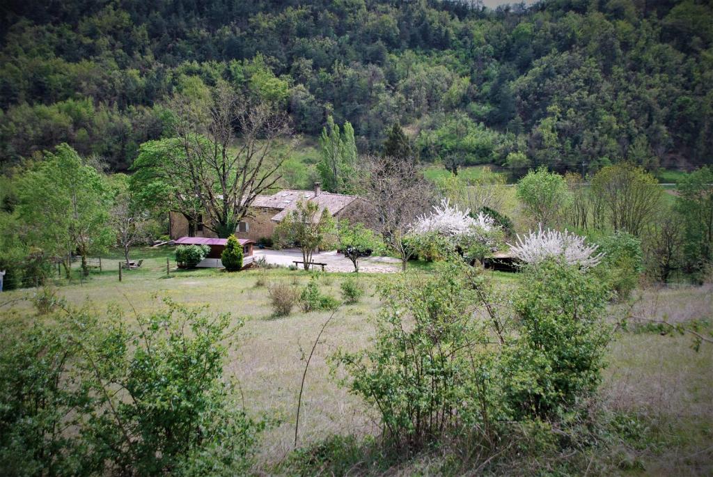 uma casa no meio de um campo com árvores em Maison d'hôtes Ainsi Soie t-il em Combovin