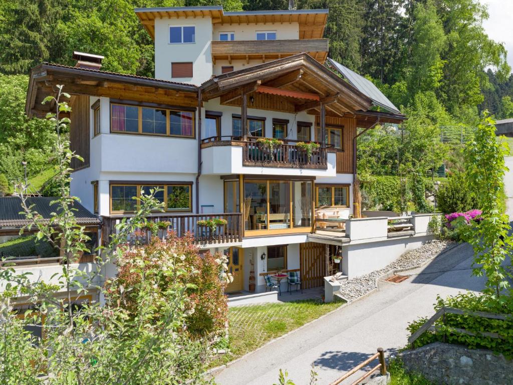 een groot huis met een balkon en bomen bij Ferienwohnung Petra in Bruck am Ziller