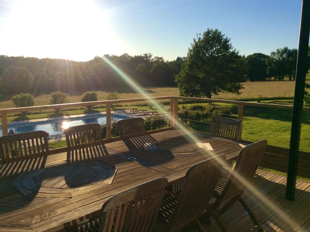 a wooden deck with chairs and a view of a river at Maison de 3 chambres avec piscine partagee jacuzzi et jardin amenage a Abjat sur Bandiat in Fargeas