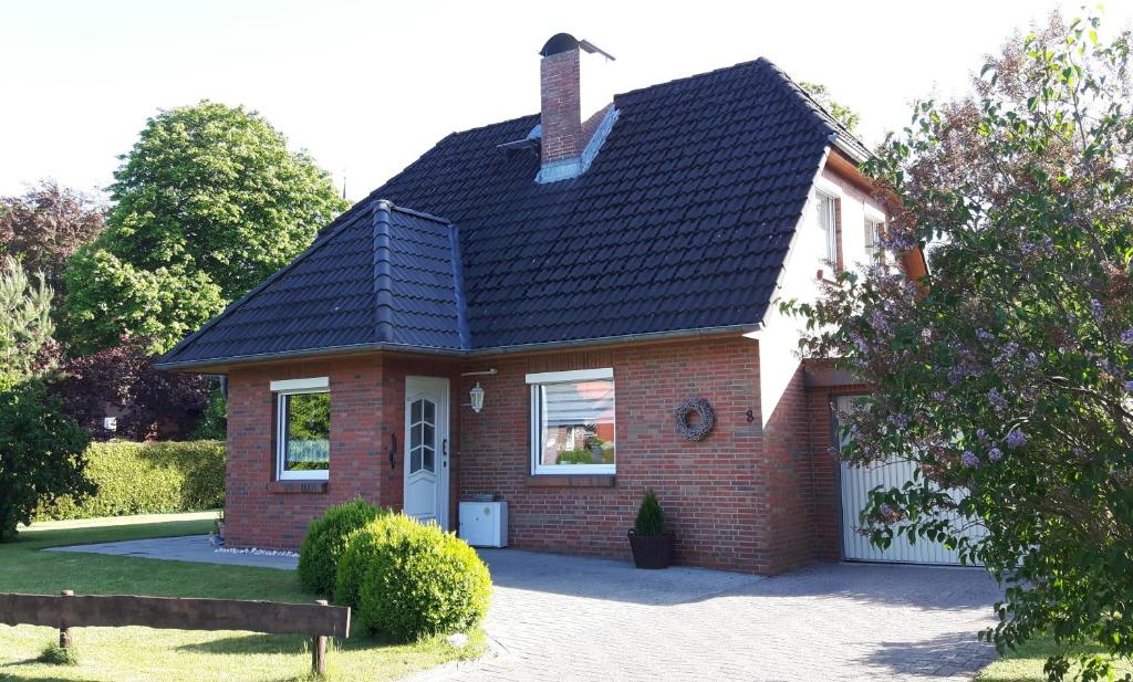 une maison en briques rouges avec un toit noir dans l'établissement Ferienhaus Gartenstraße, à Osten