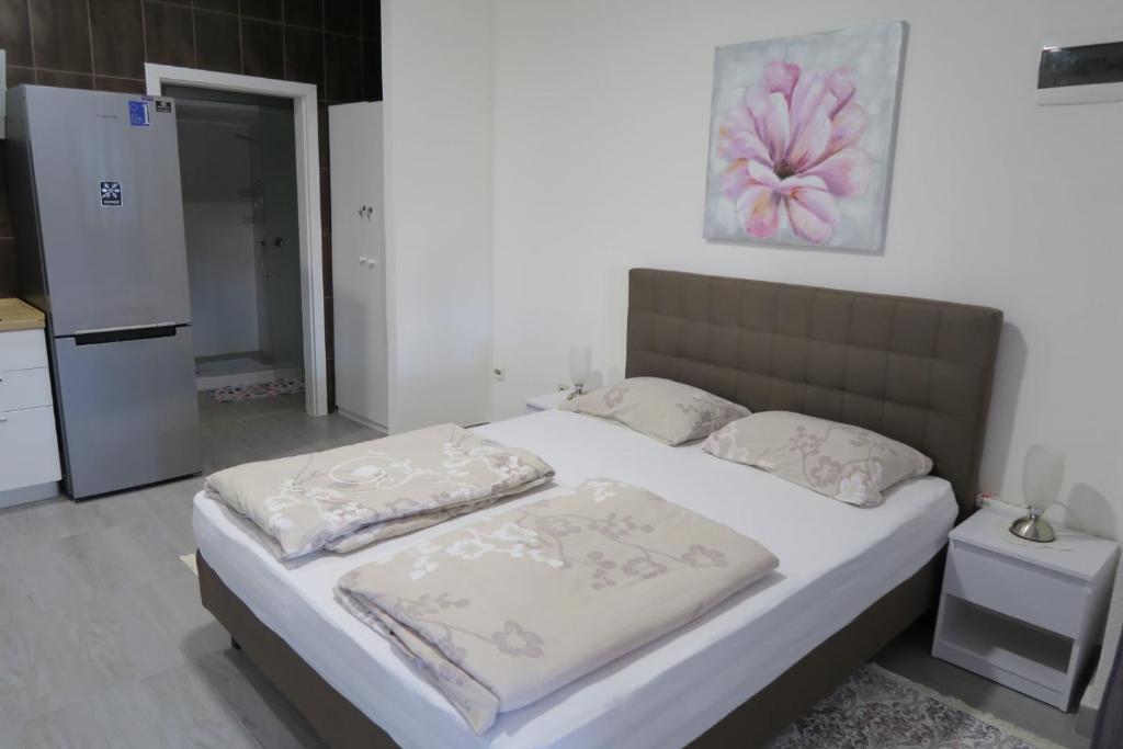 een slaapkamer met een bed met witte lakens en kussens bij Aida in Novi Vinodolski