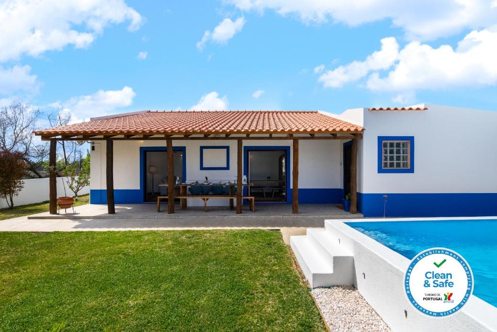 a villa with a swimming pool and a house at WHome | Comporta Family Beach House in Comporta