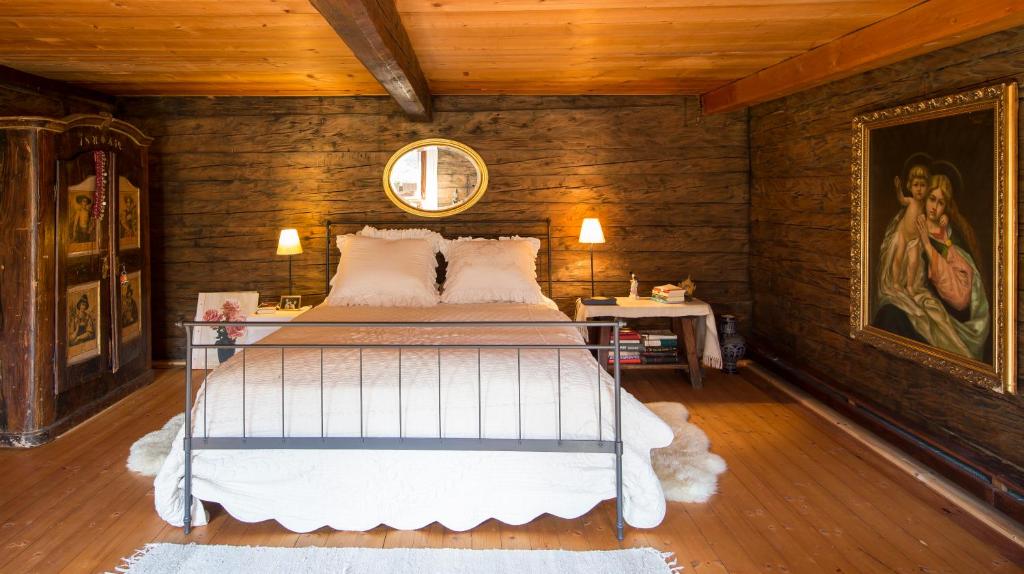 um quarto com uma cama num quarto com paredes de madeira em Speckbacher Hof - Historisches Bauernhaus im Chiemgau em Unterwössen